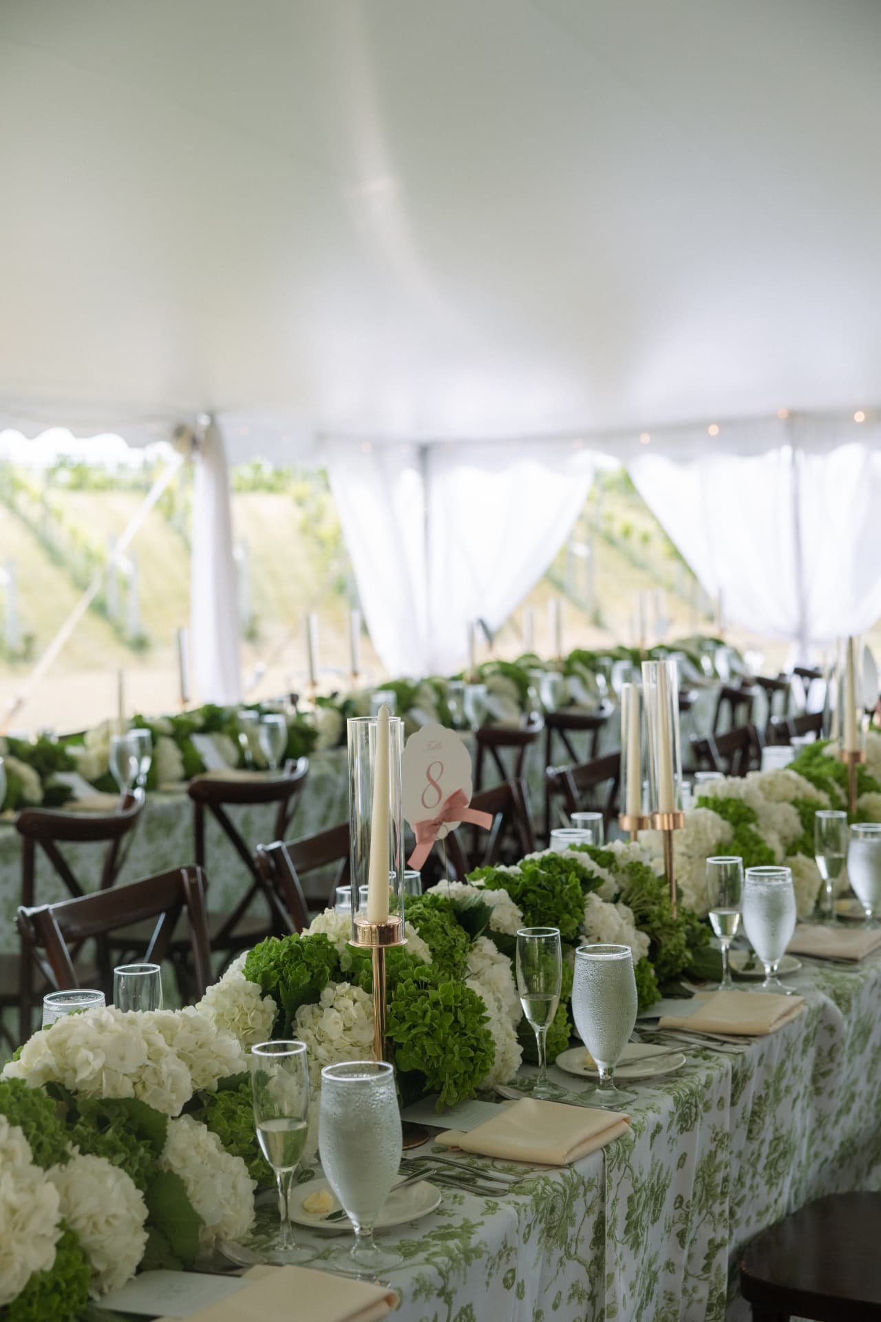 Tented reception table with green and white hydrangea centerpieces